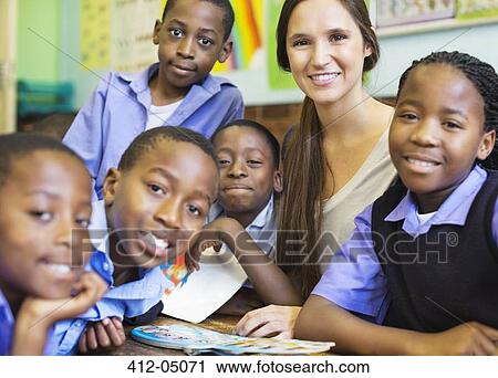 Stock Image - Teacher and students smiling in class. Fotosearch