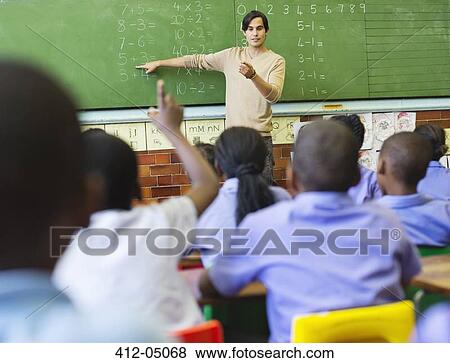 Stock Photo - Teacher talking to students at chalkboard. Fotosearch
