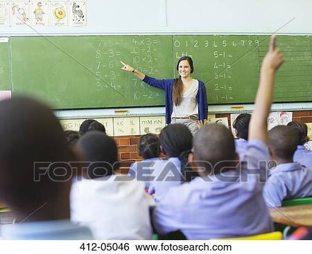 Teacher talking to students at chalkboard View Large Photo Image Stock Photograph - Teacher talking to students at chalkboard. Fotosearch