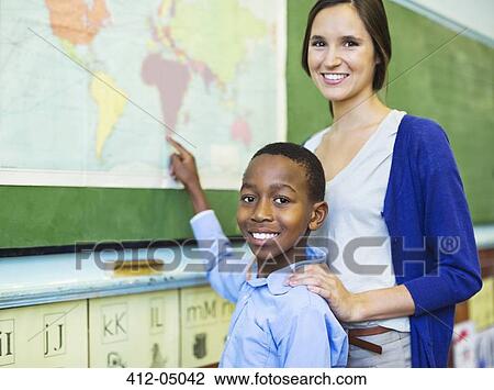 Stock Image - Teacher with student using world map. Fotosearch
