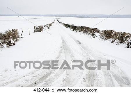 Stock Photography - Tire tracks on snowy rural road. Fotosearch