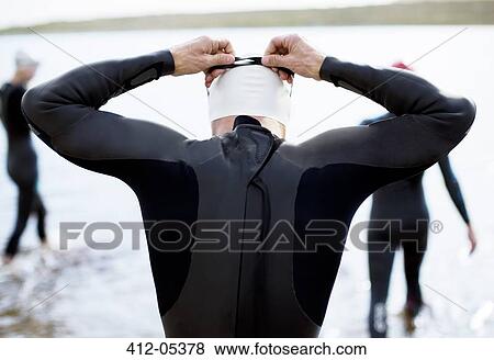Triathlete adjusting goggles at start of race View Large Photo Image Stock Photo - Triathlete adjusting goggles at start of race. Fotosearch