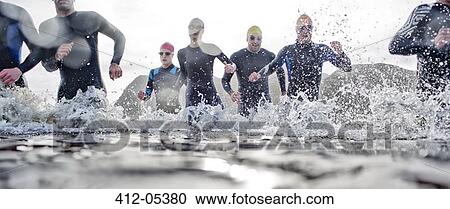 Triathletes emerging from water View Large Photo Image Stock Image - Triathletes emerging from water. Fotosearch