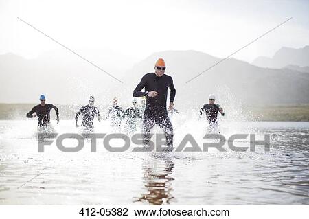 Triathletes emerging from water View Large Photo Image Stock Image - Triathletes emerging from water. Fotosearch