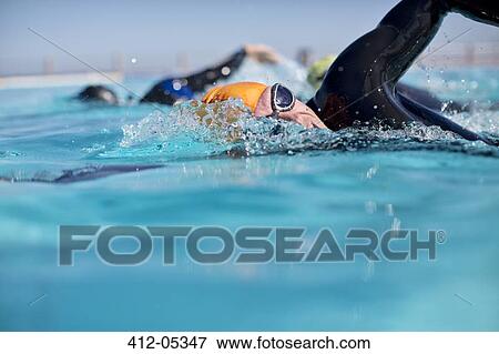 Triathletes in wetsuit splashing in pool View Large Photo Image Stock Photo - Triathletes in wetsuit splashing in pool. Fotosearch