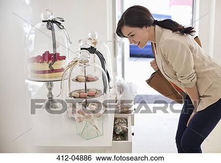 Woman admiring cookies in store View Large Photo Image Stock Photograph - Woman admiring cookies in store. Fotosearch