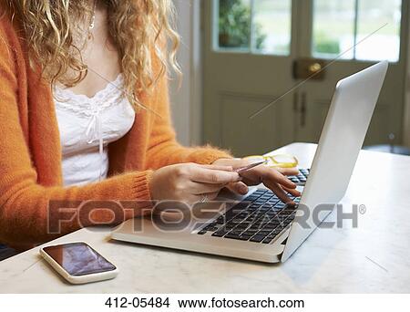 Picture - Woman shopping on laptop. Fotosearch