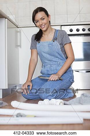 Woman working on pipes in kitchen View Large Photo Image Stock Image - Woman working on pipes in kitchen. Fotosearch
