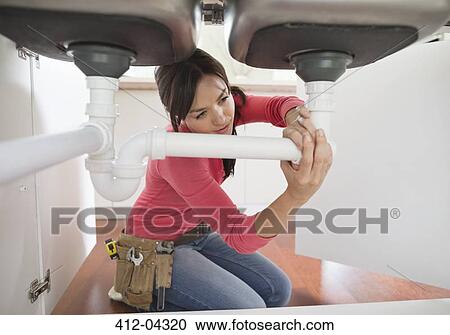 Woman working on pipes under kitchen sink View Large Photo Image Stock Image - Woman working on pipes under kitchen sink. Fotosearch