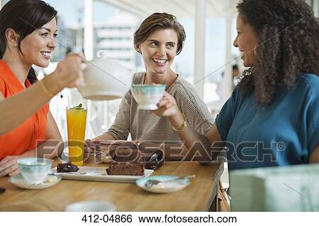 Stock Photograph - Women having coffee and cake together. Fotosearch