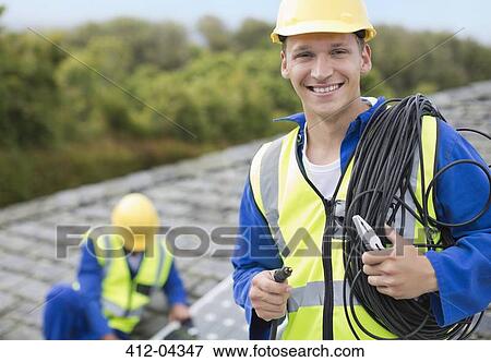 Worker smiling on rooftop View Large Photo Image Stock Photo - Worker smiling on rooftop. Fotosearch