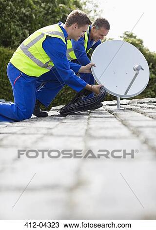 Workers installing satellite dish on roof View Large Photo Image Stock Image - Workers installing satellite dish on roof. Fotosearch
