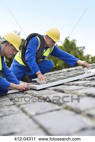 Workers installing solar panels on roof View Large Photo Image Stock Image - Workers installing solar panels on roof. Fotosearch
