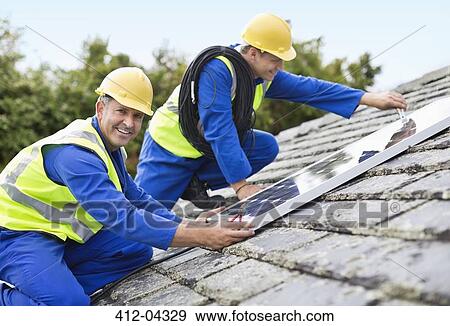 Workers installing solar panels on roof View Large Photo Image Stock Photo - Workers installing solar panels on roof. Fotosearch