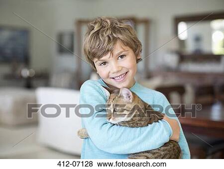 Boy hugging cat in living room View Large Photo Image Stock Photo - Boy hugging cat in living room. Fotosearch