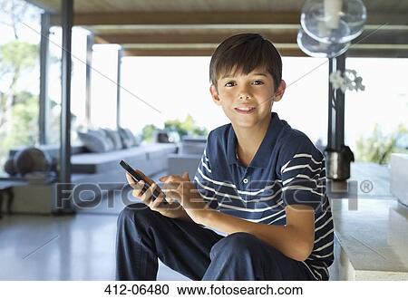 Stock Image - Boy using cell phone on steps. Fotosearch
