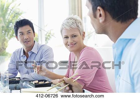 Business people eating sushi in office View Large Photo Image Stock Photograph - Business people eating sushi in office. Fotosearch