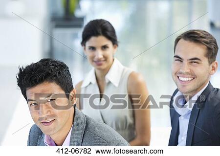 Stock Image - Business people smiling in office. Fotosearch