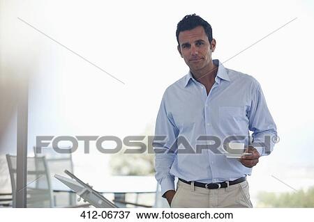 Stock Photo - Businessman having cup of coffee in office. Fotosearch