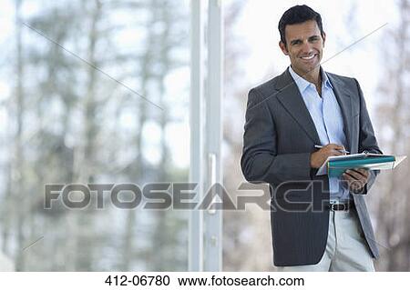 Businessman making notes at office window View Large Photo Image Stock Image - Businessman making notes at office window. Fotosearch