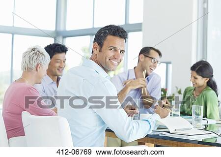 Businessman smiling in lunch meeting View Large Photo Image Stock Photo - Businessman smiling in lunch meeting. Fotosearch