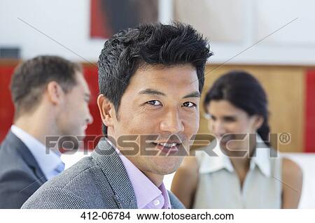 Businessman smiling in office View Large Photo Image Picture - Businessman smiling in office. Fotosearch