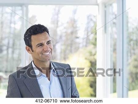 Businessman smiling in office View Large Photo Image Stock Image - Businessman smiling in office. Fotosearch
