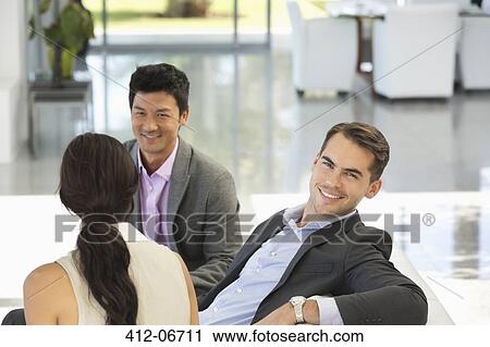 Stock Image - Businessman smiling in office. Fotosearch