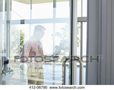 Businessman using tablet computer at office window View Large Photo Image Stock Image - Businessman using tablet computer at office window. Fotosearch