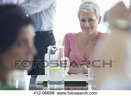 Businesswoman smiling in meeting View Large Photo Image Stock Photo - Businesswoman smiling in meeting. Fotosearch