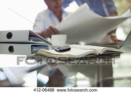 Stock Photo - Cell phone on businessman's desk. Fotosearch
