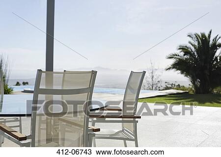 Chairs and table on modern porch View Large Photo Image Stock Image - Chairs and table on modern porch. Fotosearch