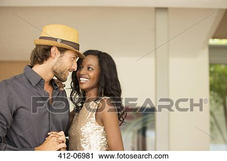 Stock Image - Couple holding hands and talking indoors. Fotosearch