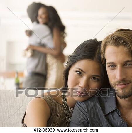 Stock Photo - Couple hugging on sofa. Fotosearch