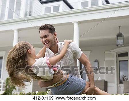 Couple playing outside house View Large Photo Image Stock Photo - Couple playing outside house. Fotosearch