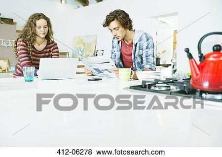 Couple relaxing together in kitchen View Large Photo Image Stock Photo - Couple relaxing together in kitchen. Fotosearch
