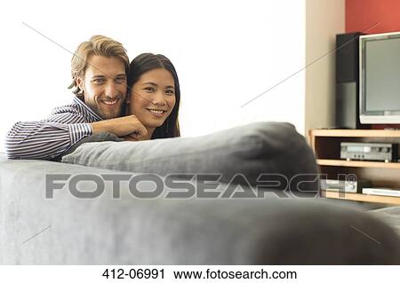 Couple relaxing together on sofa View Large Photo Image Stock Image - Couple relaxing together on sofa. Fotosearch