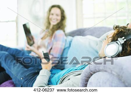 Couple relaxing together on sofa View Large Photo Image Stock Photo - Couple relaxing together on sofa. Fotosearch