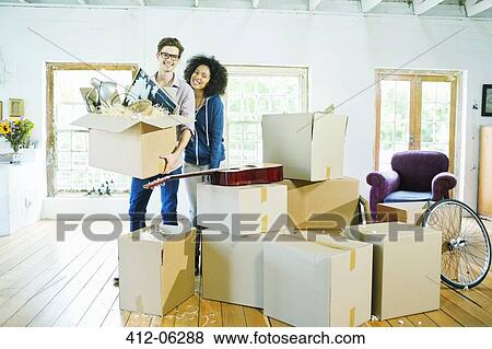 Couple unpacking boxes in new home View Large Photo Image Stock Photo - Couple unpacking boxes in new home. Fotosearch