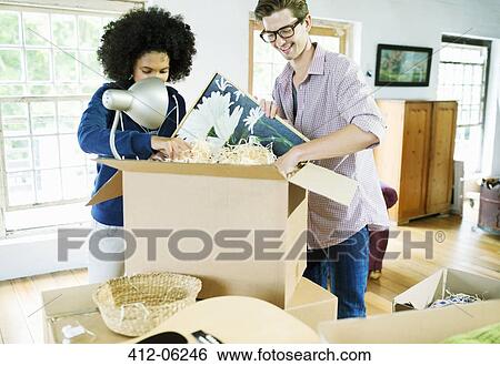 Stock Photograph - Couple unpacking boxes in new home. Fotosearch