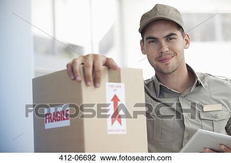 Delivery boy carrying? fragile? packag View Large Photo Image Stock Image - Delivery boy carrying? fragile? packag. Fotosearch