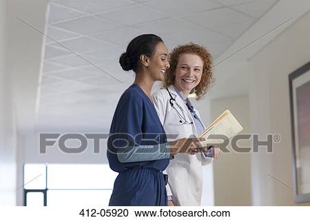 Doctor and nurse talking in hospital hallway View Large Photo Image Stock Image - Doctor and nurse talking in hospital hallway. Fotosearch