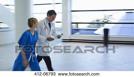 Doctor and nurse talking in hospital hallway View Large Photo Image Stock Image - Doctor and nurse talking in hospital hallway. Fotosearch