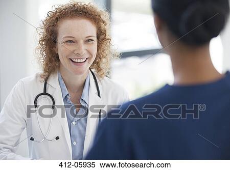Doctor and nurse talking in hospital hallway View Large Photo Image Stock Photography - Doctor and nurse talking in hospital hallway. Fotosearch