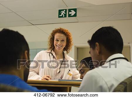 Doctor talking to hospital staff at front desk View Large Photo Image Stock Image - Doctor talking to hospital staff at front desk. Fotosearch