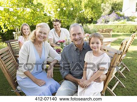 Family smiling at table outdoors View Large Photo Image Stock Image - Family smiling at table outdoors. Fotosearch