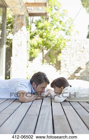 Father and daughter laying on porch View Large Photo Image Stock Image - Father and daughter laying on porch. Fotosearch