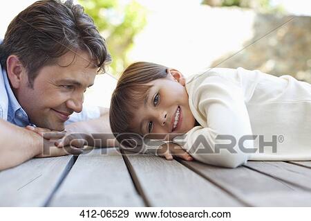 Father and daughter laying on porch View Large Photo Image Stock Photo - Father and daughter laying on porch. Fotosearch