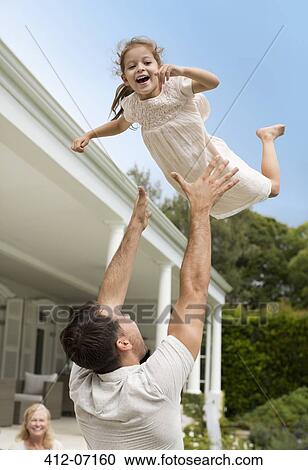Father and daughter playing outside house View Large Photo Image Stock Image - Father and daughter playing outside house. Fotosearch