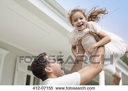 Father and daughter playing outside house View Large Photo Image Stock Photography - Father and daughter playing outside house. Fotosearch